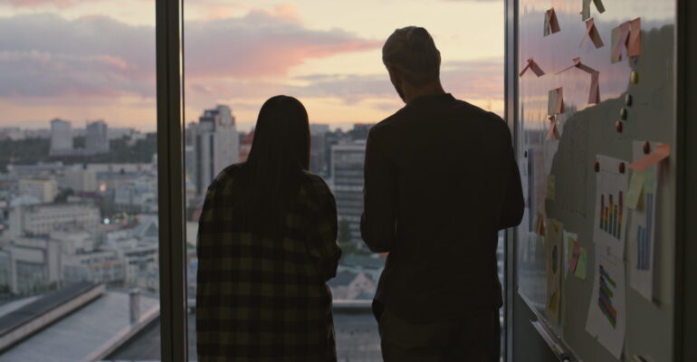 Business people silhouettes talking at dusk workplace close up. Team discussing