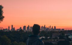 Rear View Of Man And Buildings Against Sky During Sunset